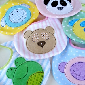 May include: Six colorful baby bibs with different animal designs. The bibs are made of soft fabric and have a variety of patterns, including polka dots, stripes, and checkered.