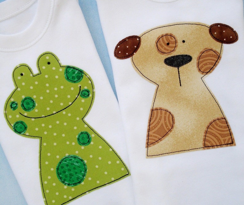 May include: Two white baby onesies with appliques. One onesie has a green frog with white polka dots. The other onesie has a brown dog with brown and white spots.