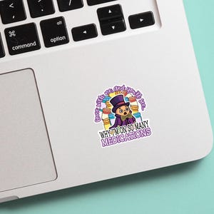 Op de afbeelding: Een kleurrijke sticker met een stripfiguur in een paarse hoge hoed en jas, omringd door medicijnflesjes. De tekst op de sticker luidt: "Houd van mij en je zult zien waarom ik zoveel medicijnen gebruik."