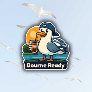 May include: A sticker featuring a cartoon seagull wearing a backward baseball cap, holding a beverage, and standing on a grassy area. The sticker includes the text "Bourne Ready" and a bridge in the background. Several seagulls are flying in the sky.