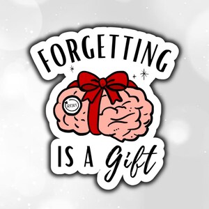May include: A sticker with a cartoon brain wrapped with a red bow. The brain has a "reset" button and the text "Forgetting is a Gift" in black script.