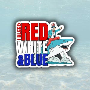 May include: A sticker with the text "I BLEED RED WHITE & BLUE". The graphic shows Uncle Sam riding a blue shark. The text is in red, white, and blue.