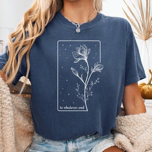 May include: A navy blue t-shirt with a white graphic of a flower with the text "to whatever end" underneath.