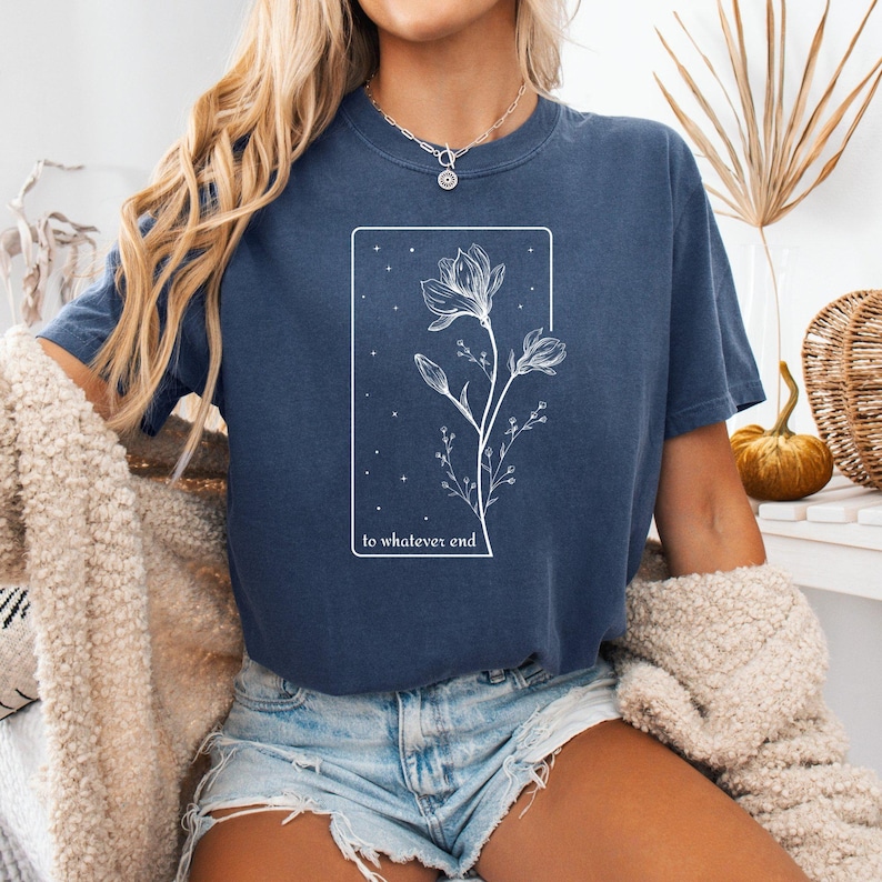 May include: A navy blue t-shirt with a white graphic of a flower with the text "to whatever end" underneath.