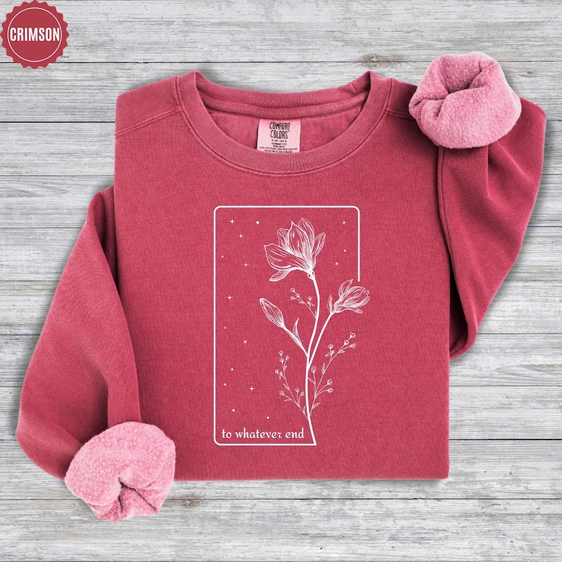 May include: Crimson red sweatshirt with a white floral design and the text "to whatever end".