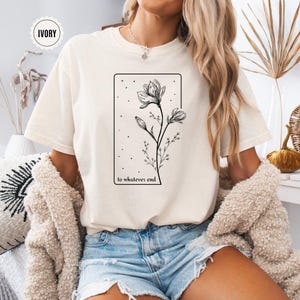 May include: A white t-shirt with a black line drawing of a flower and the text "to whatever end".