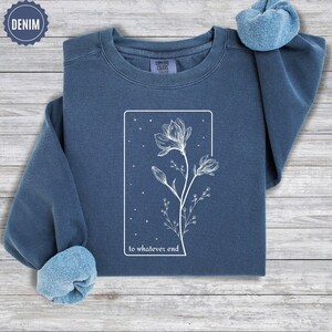May include: A dark blue sweatshirt with a white outline of a flower and the text "to whatever end".