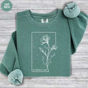 May include: A light green sweatshirt with a white graphic of a flower and the text "to whatever end".
