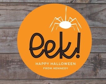 May include: An orange circular graphic with a white spider illustration and the word "eek!" in black script. The text "Happy Halloween From Kennedy" is below the word "eek!". The background is a wooden plank design.