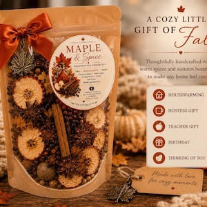 May include: A clear pouch of Maple & Spice simmer pot ingredients featuring dried apple slices, cinnamon sticks, star anise, and botanicals. The pouch is topped with a rust-coloured ribbon and a metal maple leaf charm, with a label detailing ingredients.