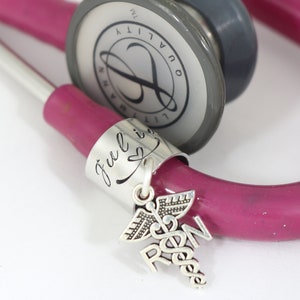 Silver personalized stethoscope tag with nurse RN charm attached.