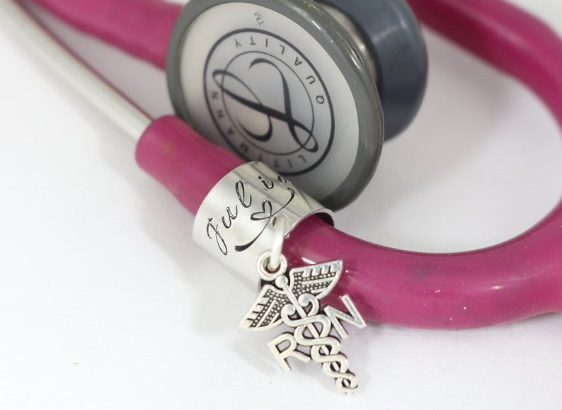 Silver personalized stethoscope tag with nurse RN charm attached.