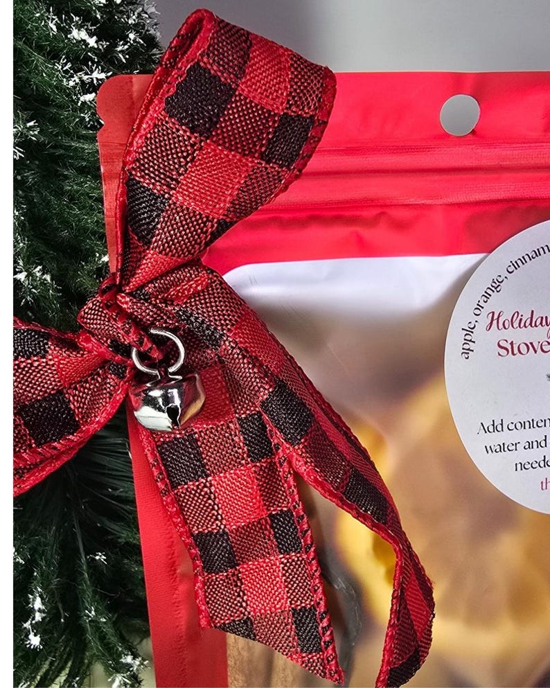 Red and black plaid bow with silver jingle bell charm on a simmer pot bag.