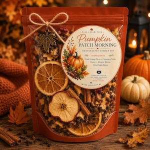 Peut inclure: Un sachet transparent contenant un mélange pour pot-pourri mijoté avec des tranches d'orange séchées, des morceaux de pomme, des bâtons de cannelle et des clous de girofle. L'étiquette indique Pumpkin Patch Morning et liste les ingrédients.