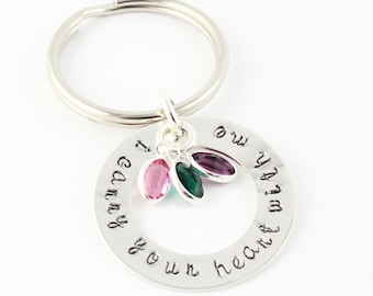 May include: Silver keychain with a round charm that says "I carry you in my heart" with three small crystal charms in pink, green, and purple.