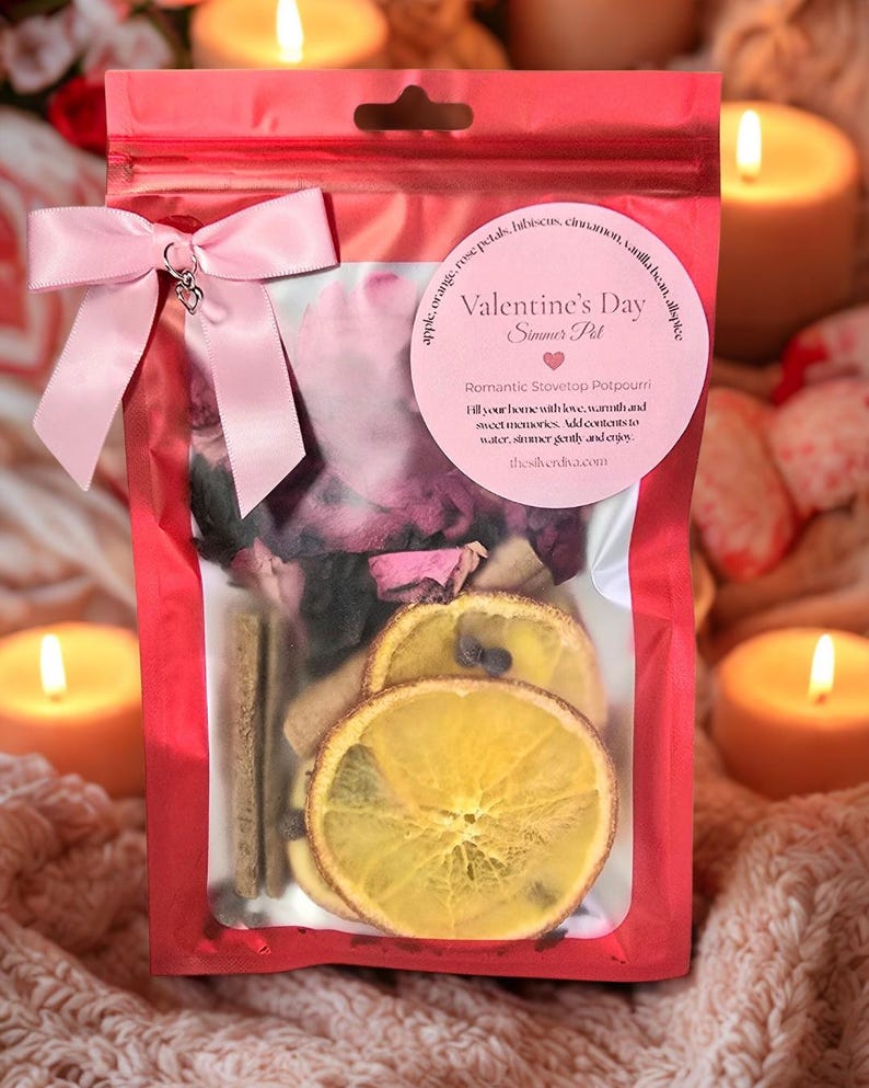 Pu&ograve; includere: Un sacchetto di cellophane rosso pieno di pot-pourri, legato con un fiocco rosa. La busta contiene fette d'arancia essiccate, bastoncini di cannella e petali di rosa. Un'etichetta rosa recita "Valentine's Day Simmer Pot".