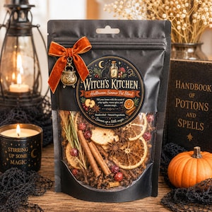 Puede incluir: Una bolsa negra con una mezcla para olla de Halloween que contiene rodajas de naranja secas, ramas de canela, anís estrellado y bayas. La etiqueta dice Witch's Kitchen, con un lazo de terciopelo naranja y un dije de caldero de metal.