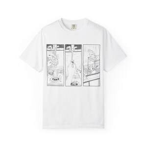 Puede incluir: Una camiseta blanca de manga corta con un gráfico de cómic en blanco y negro de tres paneles en la parte delantera. La ilustración muestra una secuencia de lavado de platos en un fregadero, incluyendo el enjuague y el secado.
