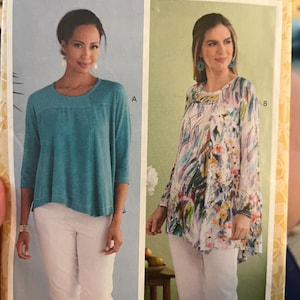 May include: A Butterick sewing pattern, B6735, featuring two women modeling tops. One woman wears a teal top with white pants, the other a floral top with white pants. The pattern includes sizes XSM-MED.