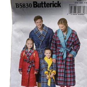 May include: A pattern for kids' robes by Butterick, featuring a family wearing robes in various plaid patterns. The robes are in red, blue, and yellow, with matching belts. The pattern includes sizes 3-4, 5-6, and 7-8.