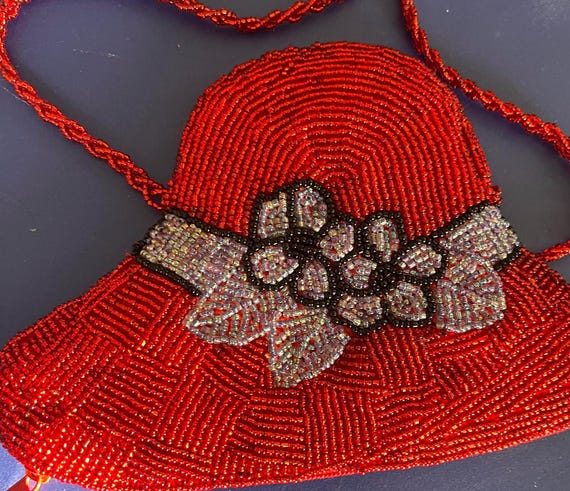 Red hat Society beaded evening bag 22 inch drop brimmed with blue flowers.