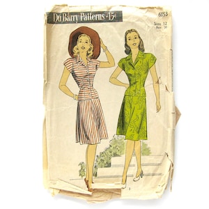 May include: Vintage sewing pattern for a dress, featuring two models wearing different styles. The pattern is from Du Barry Patterns and is size 12, bust 30. The dress on the left is striped, while the dress on the right is green with a floral print.