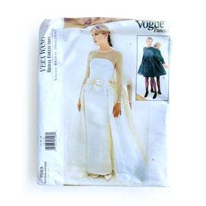 May include: A Vogue Pattern envelope featuring a Vera Wang Bridal Collection design. The image showcases a white wedding dress with a bow at the waist and a sheer neckline. The pattern number is 1583, with sizes 14-16-18.