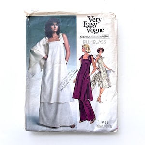 May include: Vintage Vogue sewing pattern featuring designs by Bill Blass. The cover shows illustrations of women's fashion, including a white dress and a purple pantsuit. The pattern number is 1458.