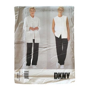 May include: A Vogue American Designer sewing pattern envelope for DKNY, model 2280. The front displays two outfits: a white long-sleeved jacket with black trousers, and a white sleeveless vest with black trousers. The text includes DKNY and 2280.