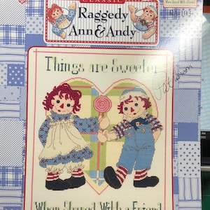 May include: Cross stitch pattern featuring Raggedy Ann and Andy holding hands. The pattern is titled "Things are Sweeter When Shared With a Friend" and is from the October 2001 issue of Classic Raggedy Ann & Andy.