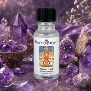 May include: A clear glass bottle with a black cap containing Sun's Eye Amethyst concentrated aroma. The white label features a sun logo, an illustration of a figure with wings, and the text Amethyst Concentrated Aroma 1/2 fl oz (15 ml).