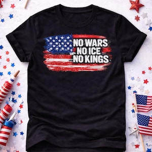 Peut inclure: T-shirt noir avec un motif de drapeau américain vieilli et le texte blanc "NO WARS NO ICE NO KINGS". L'image comprend des décorations patriotiques, comme des drapeaux et des confettis en forme d'étoiles.