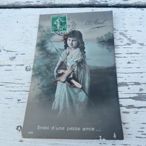Postal francesa vintage del siglo XX recoloreada adorable niña con peces Primero de abril