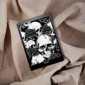 May include: A black and white Kindle e-reader with a skull and rose pattern on the screen. The text "kindle" is visible on the bottom of the screen.