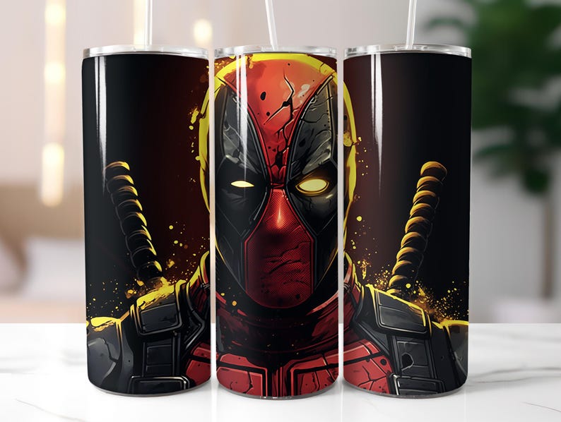 May include: A stainless steel tumbler with a black and red design featuring a close-up of Deadpool's face. The tumbler has a black lid and a straw.