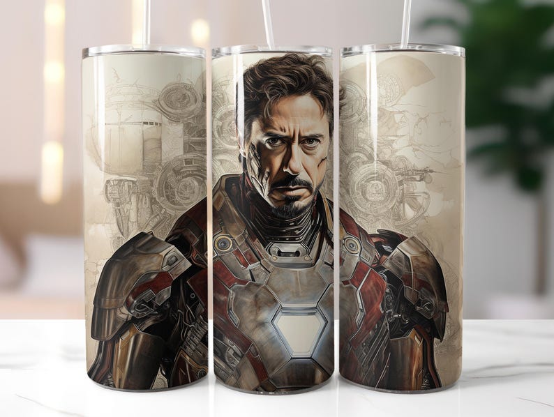 Puede incluir: Un vaso de acero inoxidable con un dise&ntilde;o que presenta a un superh&eacute;roe con un traje rojo y dorado. El fondo es una imagen descolorida de un dise&ntilde;o mec&aacute;nico.