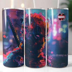 Puede incluir: Tres vasos de acero inoxidable con un dise&ntilde;o abstracto colorido que presenta un personaje de superh&eacute;roe. El dise&ntilde;o incluye salpicaduras de rosa, azul y morado. El vaso de la derecha tiene la palabra "MARVEL" impresa. El vaso de la izquierda tiene el texto "You were dreaming on!" impreso.