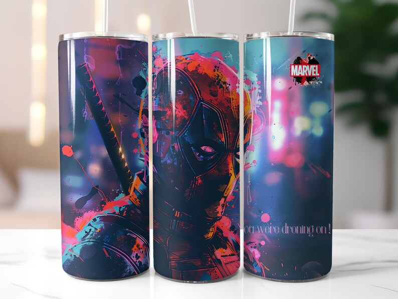 Puede incluir: Tres vasos de acero inoxidable con un dise&ntilde;o abstracto colorido que presenta un personaje de superh&eacute;roe. El dise&ntilde;o incluye salpicaduras de rosa, azul y morado. El vaso de la derecha tiene la palabra "MARVEL" impresa. El vaso de la izquierda tiene el texto "You were dreaming on!" impreso.