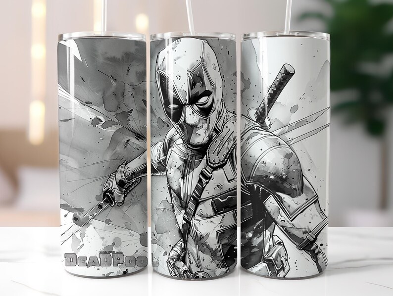 Op de afbeelding: Set van drie roestvrijstalen bekers met een zwart-wit illustratie van Deadpool. Het ontwerp toont Deadpool's masker, kostuum en zwaarden. Het woord "Deadpool" staat onderaan de bekers.