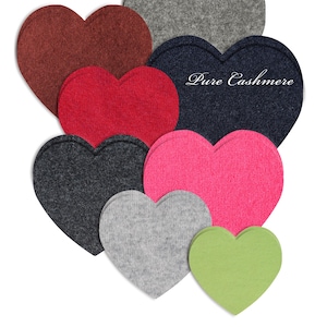 Puede incluir: Un conjunto de parches de tela en forma de corazón en varios colores, incluyendo rojo, rosa, gris y verde. Un corazón azul marino tiene el texto "Pure Cashmere". La imagen también incluye el texto "More colors & sizes available".