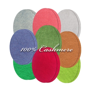 May include: Nine oval cashmere fabric swatches in shades of red, green, blue, and orange. The text "100% Cashmere" is displayed in a cursive font across the centre. The swatches are arranged in a circular pattern. Ideal for textile and fashion design.