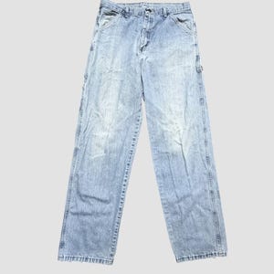 May include: Light blue denim work pants with multiple pockets and a relaxed fit. The jeans have a faded wash and a classic five-pocket design, suitable for casual wear.