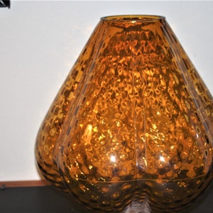 May include: A large, amber-colored glass lampshade with a textured, bubbled surface.