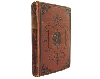 May include: A vintage red book with a black and gold design. The book has the letters "P&H" on the front cover.