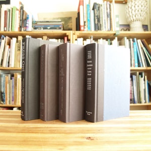 May include: Five hardback books with black and grey covers. The titles are "Press On!" "Scottoline" "Libra The First Two Novels" "Rebel Angels" and "Libra Bray".