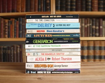 May include: A stack of paperback books with colourful covers. The titles include "Greyland", "The Time Connection", "The Early Del Rey 2", "Memo", "4 Futures", "Generation", "At The Narrow Passage", "The Rombella Shuttle", "Alicia II", "Beloved Son", and "Among The Dead".
