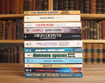 May include: A stack of paperback science fiction books with colourful covers. The titles include "The Heaven Makers", "Dragon Winter", "If the Stars Are Gods", "Multiface", "High Deryni", "Projections", "Slide Path", "Dominant Species", "Martyr", "Eye Among the Blind", and "Planet of the Voles".