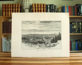 May include: A black and white engraving of a city skyline with a mountain range in the background. The city is surrounded by trees and there are two figures walking on a path in the foreground. The caption below the image reads "Smyrna, from Mount Pagos."