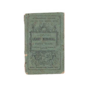 May include: A green book cover with the title "American Ladies' Memorial" in black lettering. The book is illustrated and was published in Boston in 1850.