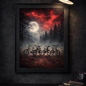 Könnte beinhalten: Gerahmter Kunstdruck mit einer surrealen Waldszene mit Vollmond, rotem Blitz und Fahrrädern. Das Kunstwerk wird in einem schwarzen Rahmen präsentiert, was einen dramatischen Kontrast zum dunklen Hintergrund erzeugt. Ein dekoratives Stück.